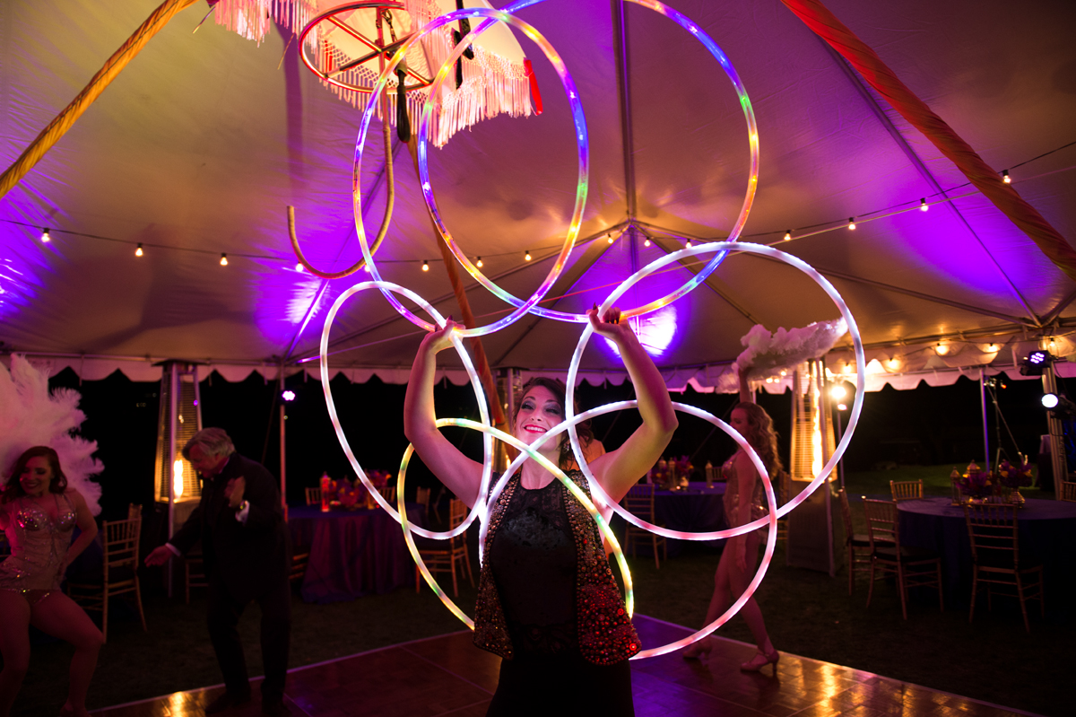 an elegant female hoop dancer performs with led hoops creating intricate patterns and colors with her movement