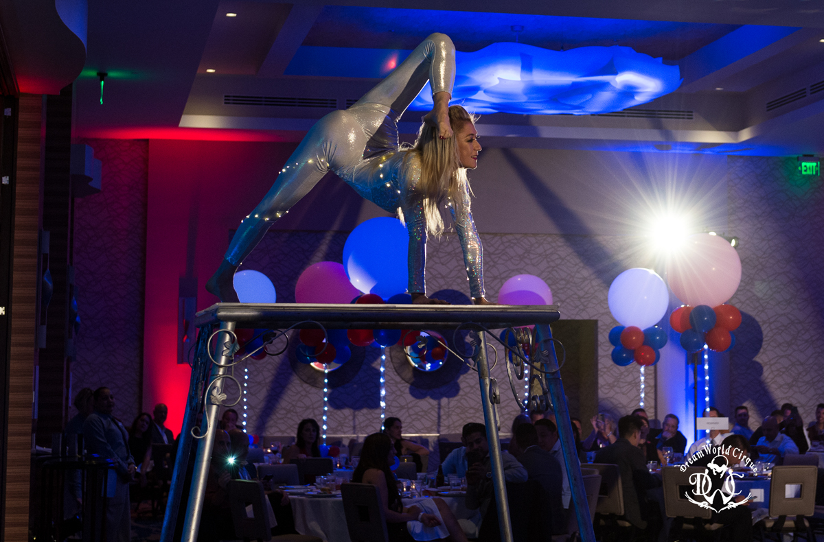 Contortionist balancing on a truss at a corporate gala