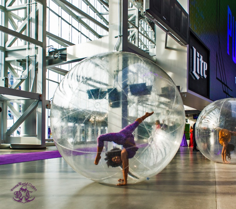 Contortionist in a Clear Sphere at a Stadium Gala Opening