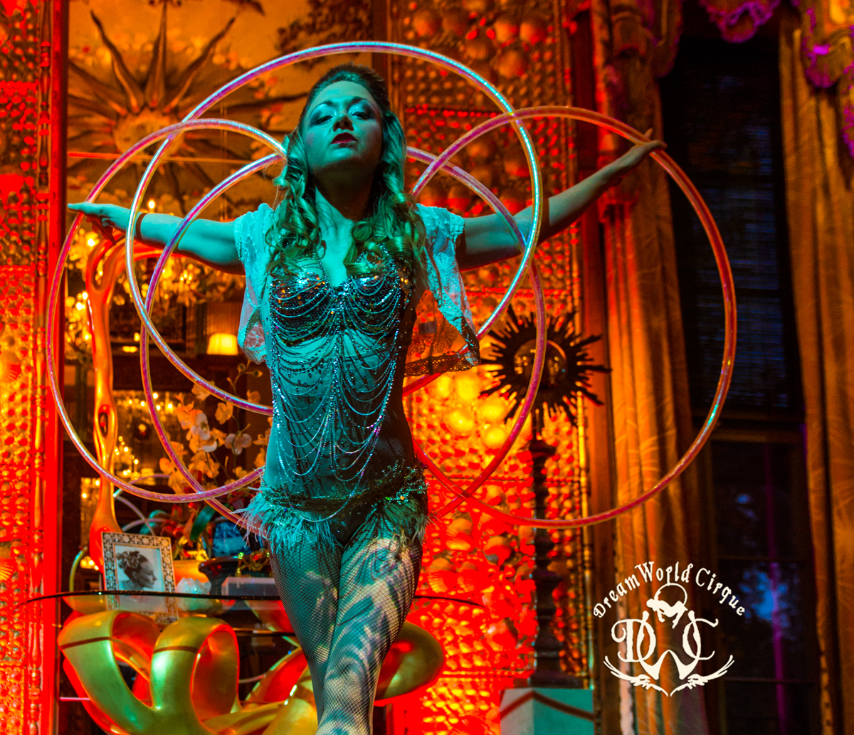 Aerial hoop performer against an ornate backdrop